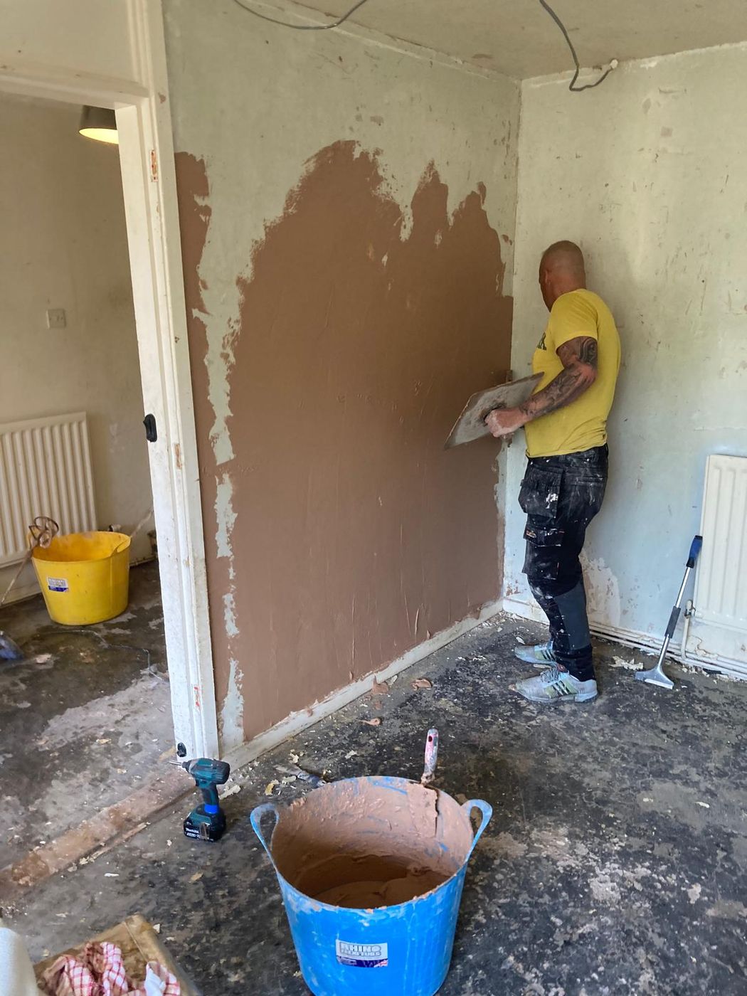 An RF Maintenance operative plastering a wall