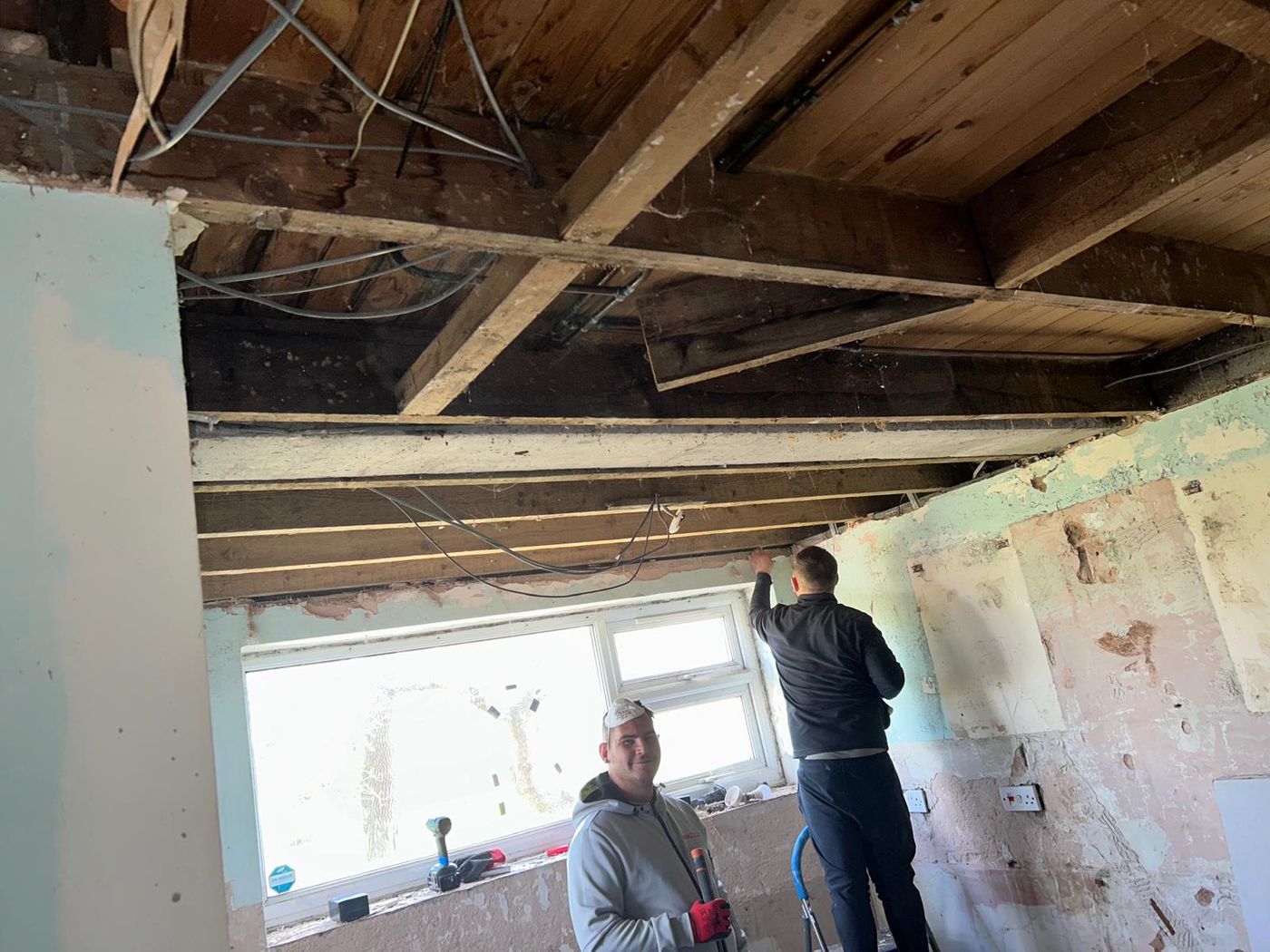 Two RF Maintenance operatives working on ceiling joists during a refurbishment